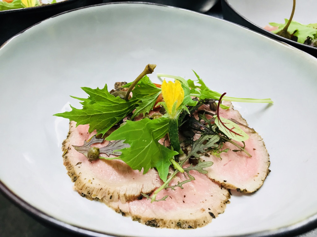 Fines tranches de viande accompagnées d’herbes fraîches