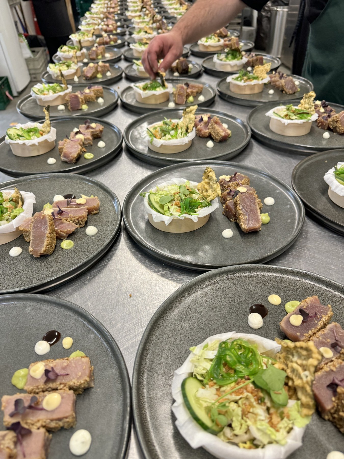 Finitions de plusieurs assiettes gastronomiques avant le service