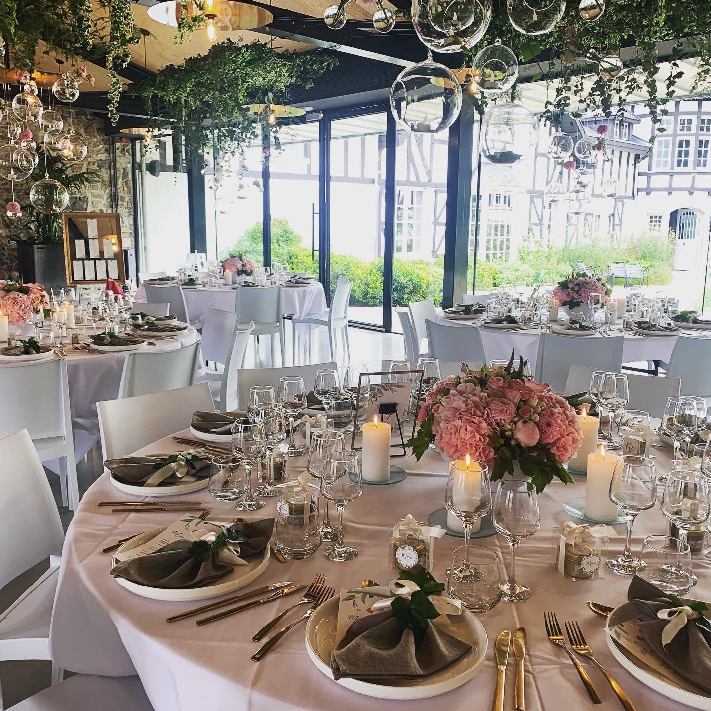 Salle de mariage décorée avec des compositions florales et des tables dressées