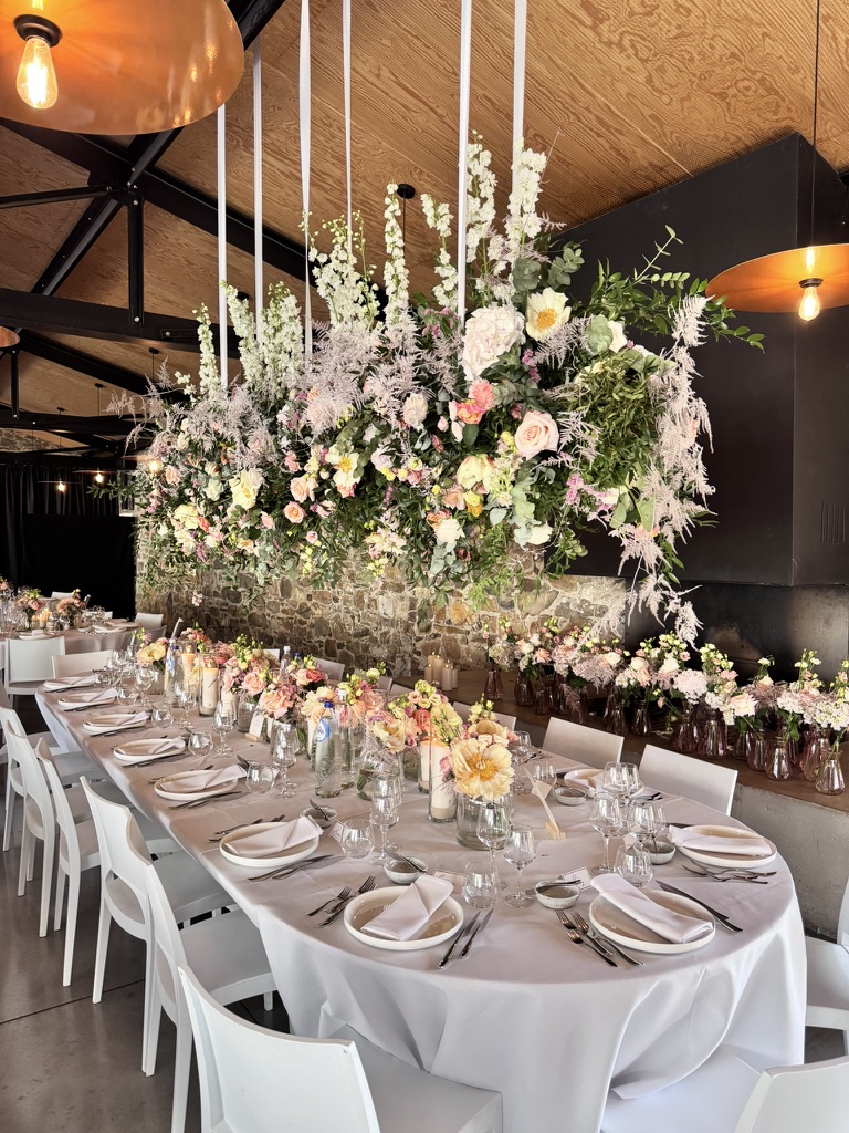 Grande table de réception fleurie et dressée pour les invités