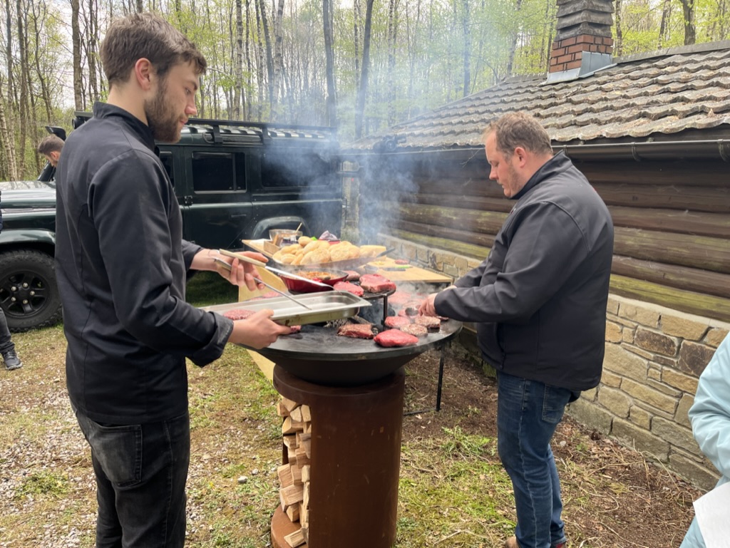 L’équipe cuisine en extérieur autour d’une plancha au feu de bois