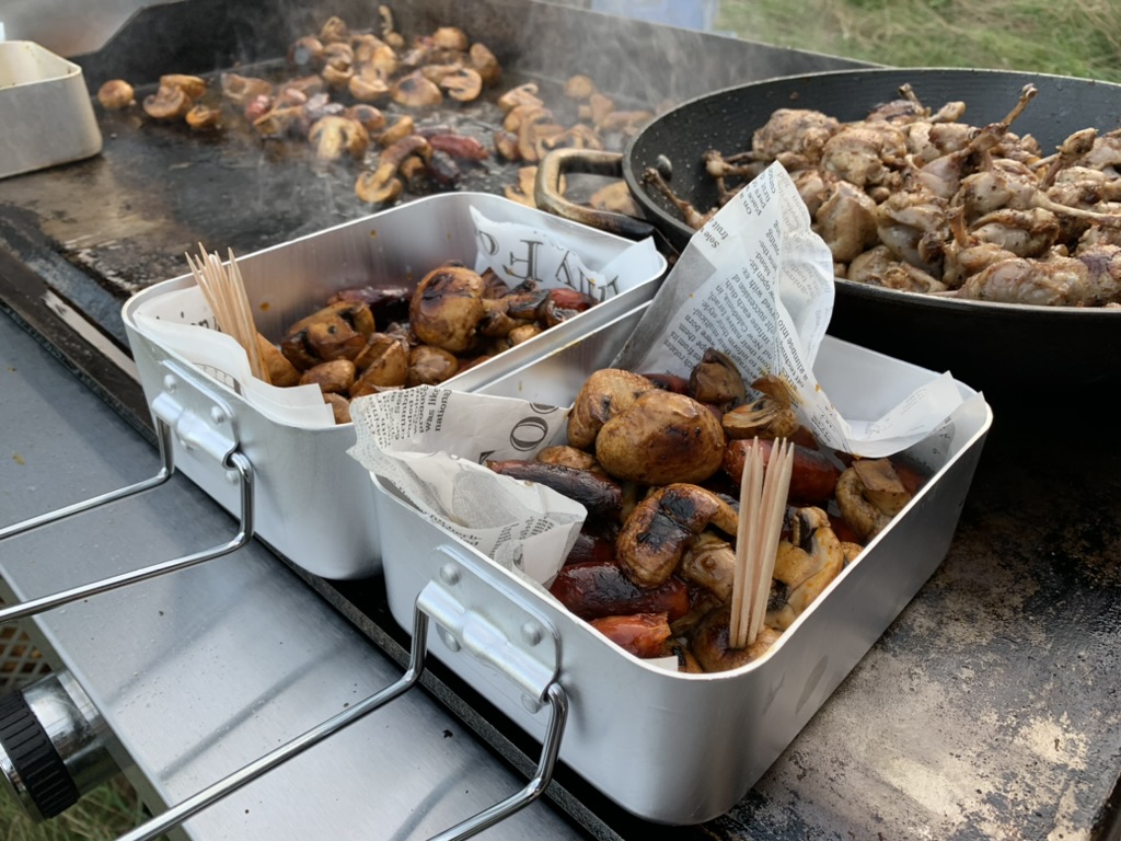 Cuisson de brochettes et de légumes sur la plancha en extérieur